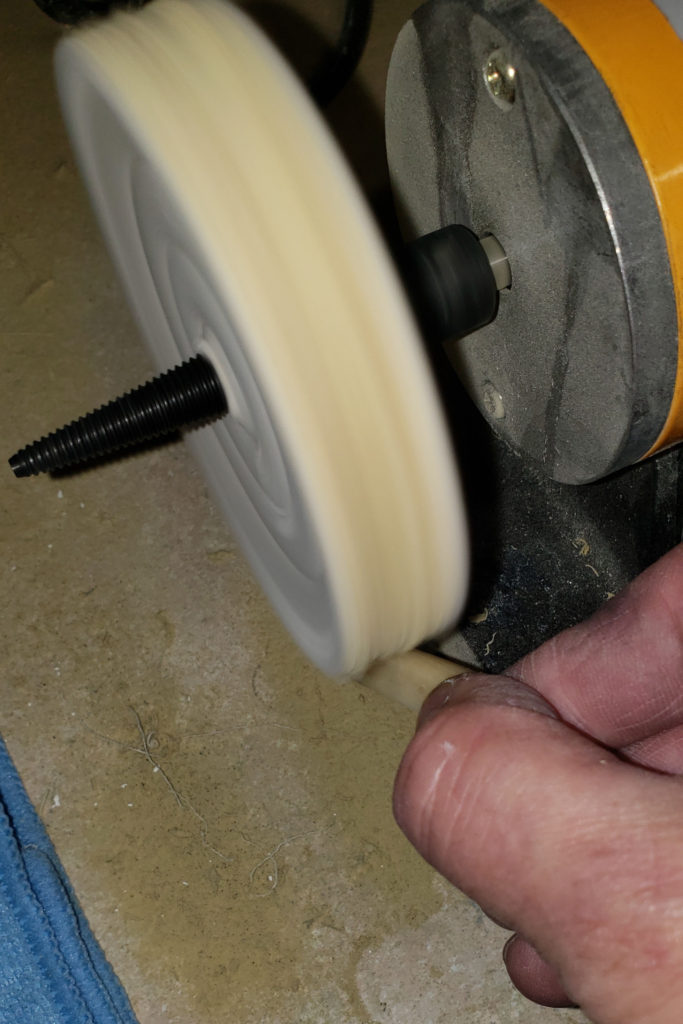 Polishing a guitar nut on buffing wheel